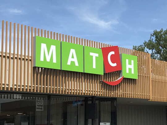 Habillage de la façade du magasin Match à Andenneavec bardage bois